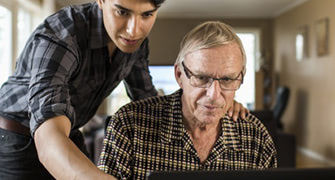 Older man with younger man looking at a screen