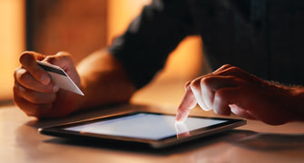 Man entering credit card details on tablet